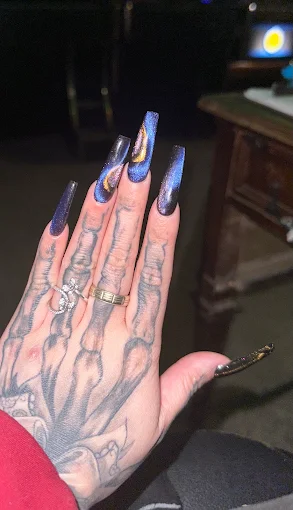 Long sculpted nails in navy, peach, and chrome finishes